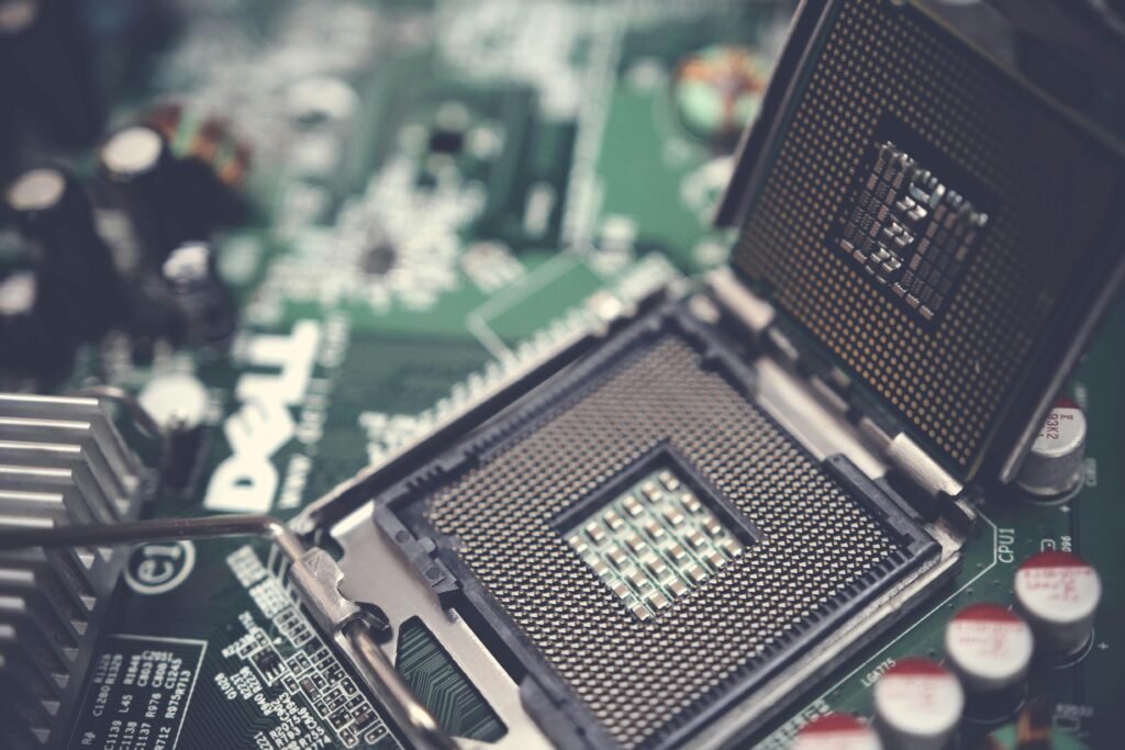pexels-photo-1432680-1432680 Detailed view of a CPU socket on a green motherboard, showcasing microprocessor technology.